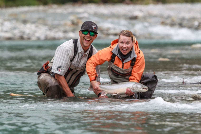 smiling with a big bull trout in her hands